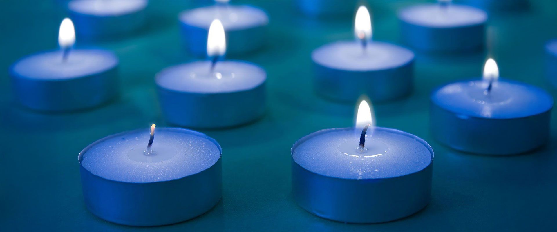 Mehrere Teelichter in blauem Licht